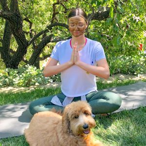Miranda Kerr practicing self-care at home doing yoga with her dog