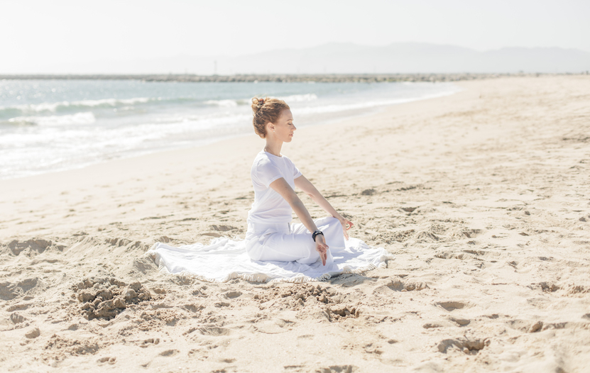Kelsey Patel in yoga pose on beach