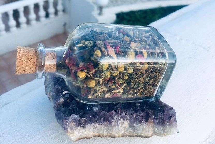 Kylie Wells herb tea in a jar on a crystal